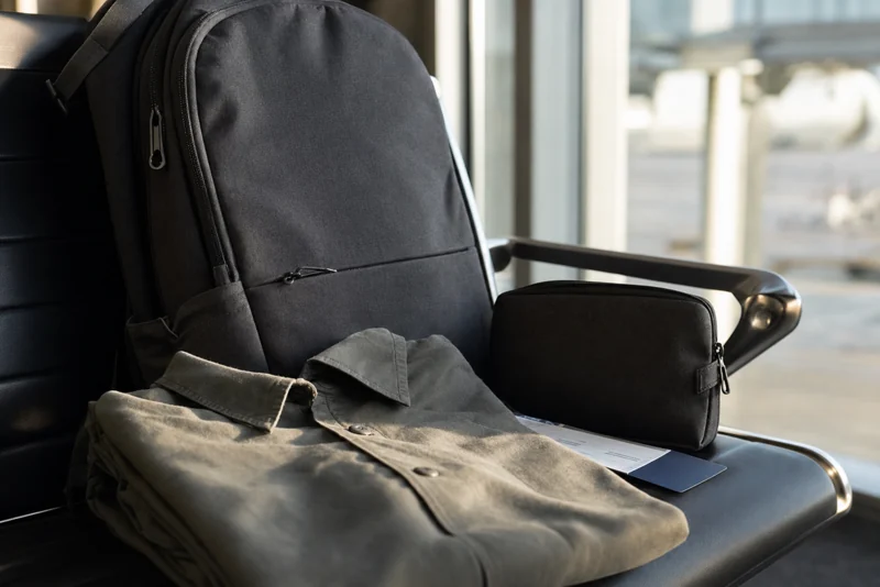 Traveler with backpack and rolling suitcase at a station